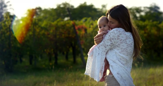 On a sunny day a mother and her baby girl immersed in the organic nature, play and laugh. Mom and baby girl having fun a lot and show love towards each other. love of a family.