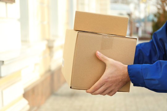 Courier with parcels outdoors, closeup