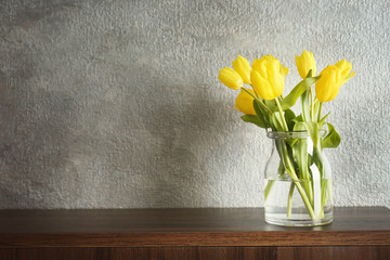 Glass vase with bouquet of beautiful tulips on color background