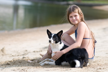 Pretty girl with her dog on the beach