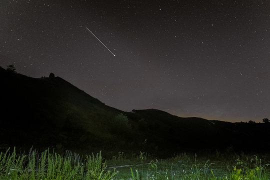 Starry landscape with meteor. Shooting star.