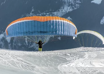 Tuinposter The pilot begins flight on a paraplane with a mountain-skiing slope of Penken - Mayrhofen, Austria © vadim_petrakov