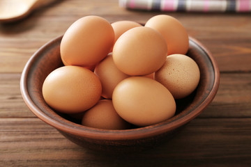 Raw eggs in bowl on kitchen table