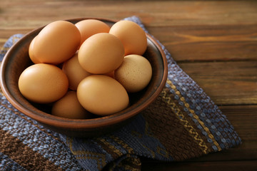 Raw eggs in bowl on kitchen table