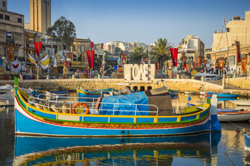 St.Julian's, Malta - Traditional colorful Luzzu fishing boat at Spinola bay at sunrise