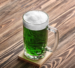 St. Patrick Day concept. Glass of green beer on wooden background