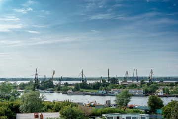 Obraz premium River Industrial Zone with cranes for loading ships. Blue sky with copy space