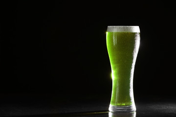 St. Patrick Day concept. Glass of green beer on black background