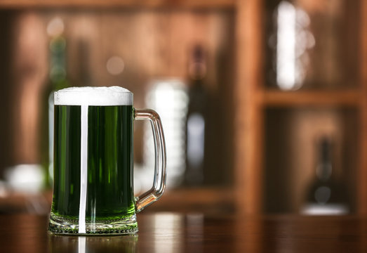 St. Patrick Day concept. Glass of green beer on bar counter