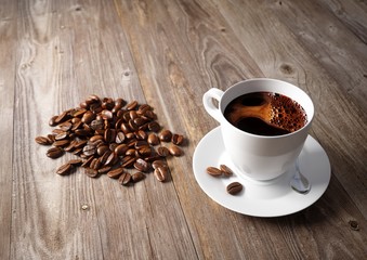 Coffee cup with roasted beans on rustic table