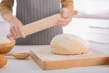 Woman preparing to roll out dough on kitchen table