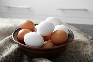 Bowl with raw eggs on kitchen table
