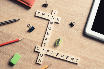 Think different concept of crossword puzzle on wooden surface