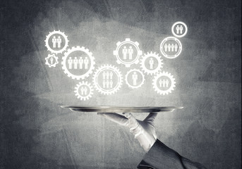 Waiter hand with white gloves holding silver plate full of social media communication icons