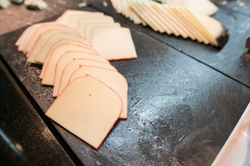 assorted cheese, Different kinds of cheeses on black plate - Top view.