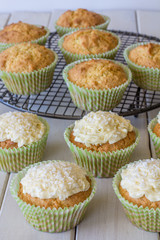 Coconut Snowball Cupcakes from the Front on a White Wooden Table with Selective Focus Vertical