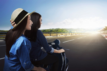 Two beautiful asian woman traveling by scooter
