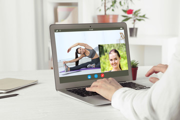 Woman watching sport training online on laptop. Fitness and sport blog.