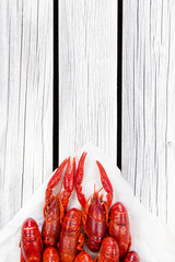 Steamed red crayfish on the white wooden background. Boiled crawfish. Rustic style.