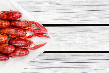 Steamed red crayfish on the white wooden background. Boiled crawfish. Rustic style.