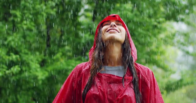 girl smiles, spins and laughs in the rain. the rain falls, the drops fall on his face and the girl is happy with life and nature around. concept of nature and happy life. Adventure, purity.