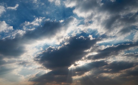 Crepuscular rays with dark cloud and blue sky.