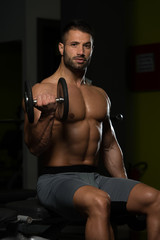Fototapeta na wymiar Biceps Exercise With Dumbbell In A Gym