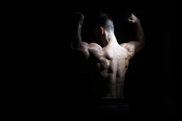 Obraz na płótnie Canvas Young Bodybuilder Flexing Muscles