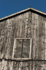 Closeup of old rustic black peeling barn with deep blue sky