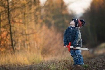 Young boy playing outdoor with wooden sword - Powered by Adobe