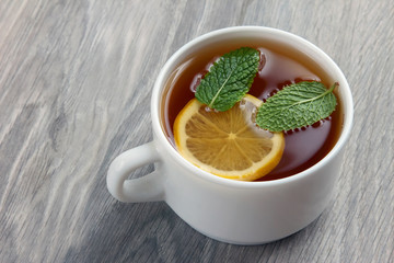 white cup of tea with lemon and mint