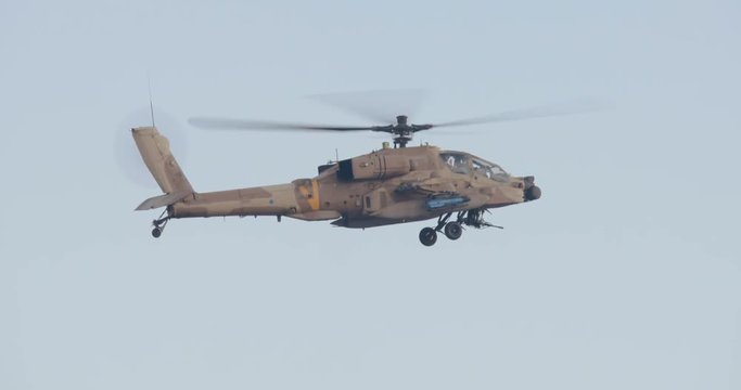 AH-64 Apache attack helicopter firing 30mm canon during combat maneuvers