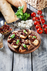 Appetizer bruschetta with sun-dried tomatoes, olives and mozarel