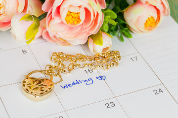 word wedding on calendar and gold bracelet with heart