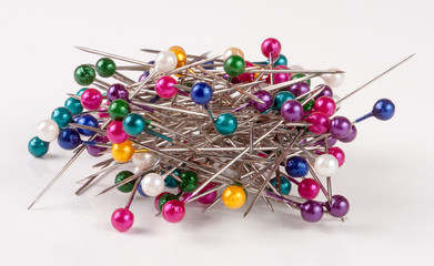 pile of  multi-colored sewing pins on a white background