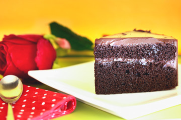 Chocolate cake with a cut piece  on green background, closeup