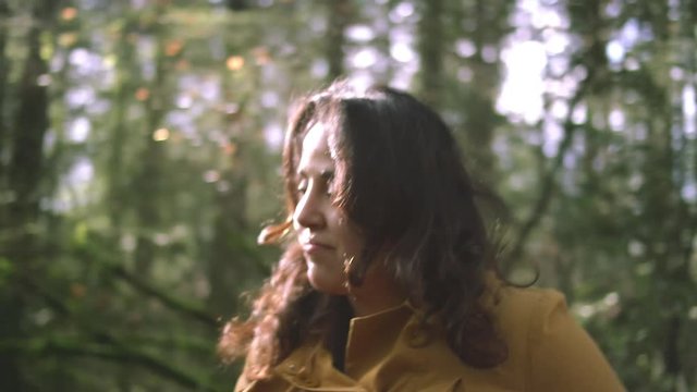 A latina woman walking through a forest, slow motion