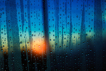 Water droplets on glass with the sunrise.
