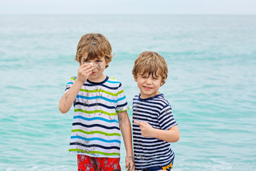 Fototapeta na wymiar Two little kids boys running on the beach of ocean