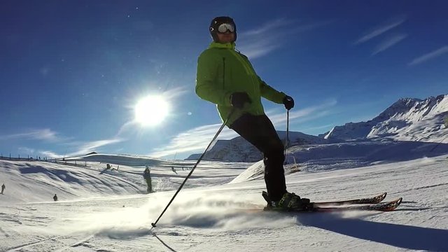 Slow motion: Man is skiing down along the slope on sunny day, Tignes, France