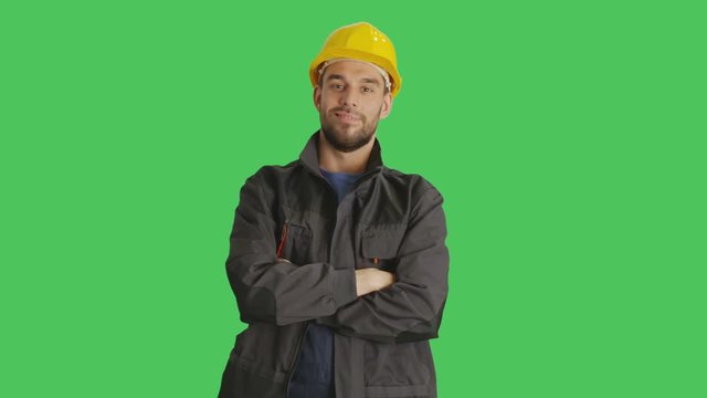 Mid Shot of a Handsome Worker Wearing Hard Hat Crossing His Arms and Smiling. Background is Green Screen. Shot on RED Cinema Camera 4K (UHD).