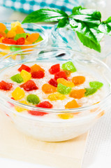 Oatmeal with colorful candied fruits in a glass bowl