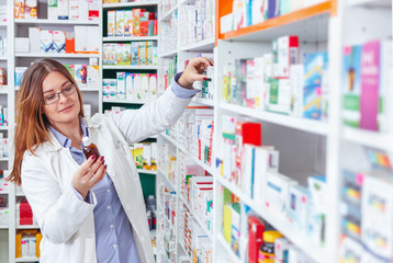 Vrouwenapotheker met recept die medicijnen controleert in de apotheek (of drogisterij)