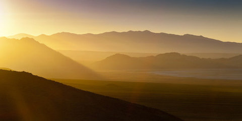Fototapeta na wymiar Desert landscape sunset with sun flare and haze