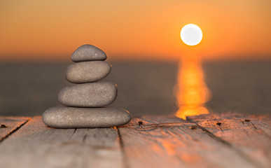Stacked pebbles and setting sun