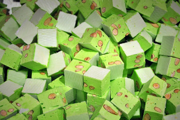 Pile of green candy paste with nuts sliced into cubes closeup