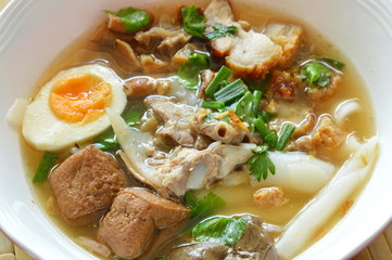 boiled Chinese pasta with pork and entrails topping creamy egg yolk in soup
