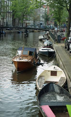 Fototapeta na wymiar Netherlands, Amsterdam. Types of cities, buildings, canals and boats. Views on the water .