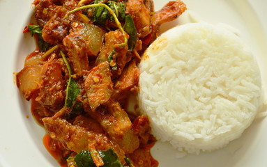 spicy stir fried roasted pork curry with herb eat couple with rice on plate