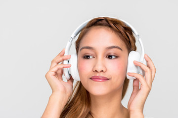 Fototapeta premium young woman listening music with wireless headphone, half latina and half asian